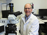 Dr. Michael Levin is pictured in a research lab. A white man wearing a lab coat.