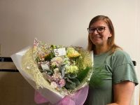 Brenda McLaren holding a bouquet of flowers.