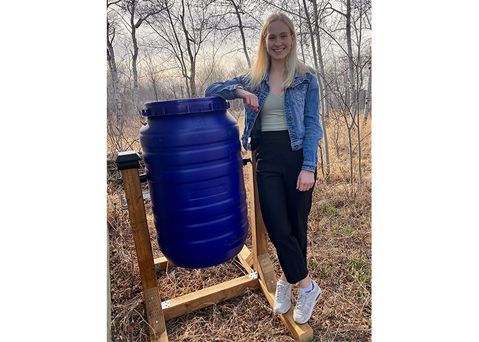 First-year medical student Brooklyn Rawlyk stands next to a compost she started after taking an interest in sustainability. Submitted photo