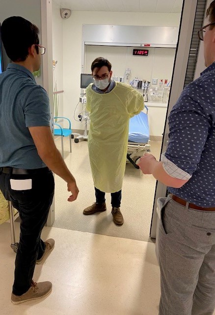 From left: Infection Prevention and Control staff member Rohit Sacheva, first-year medical student Fady Sulaiman and third-year student Brook Danger go over donning and doffing techniques. 