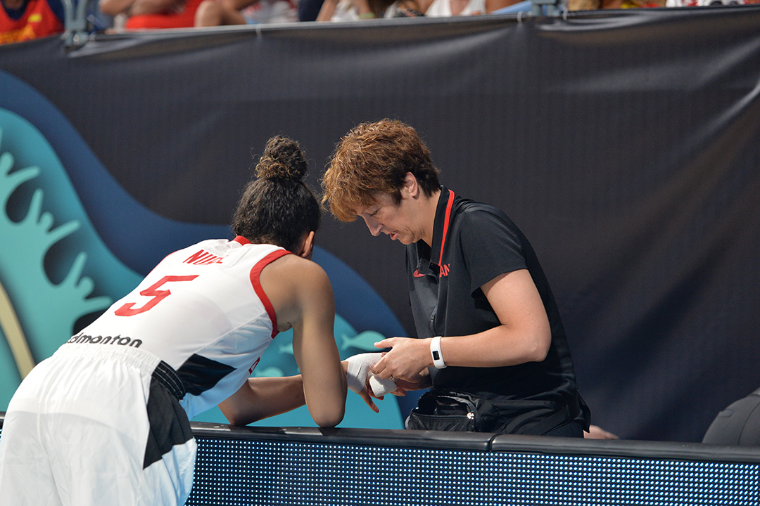 USask alumna and Team Canada physiotherapist Rhonda Shishkin tapes the hand of Olympic women’s basketball player Kia Nurse. (Photo: Basketball Canada)