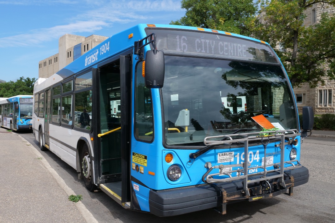 A Saskatoon city bus in front of a USask building