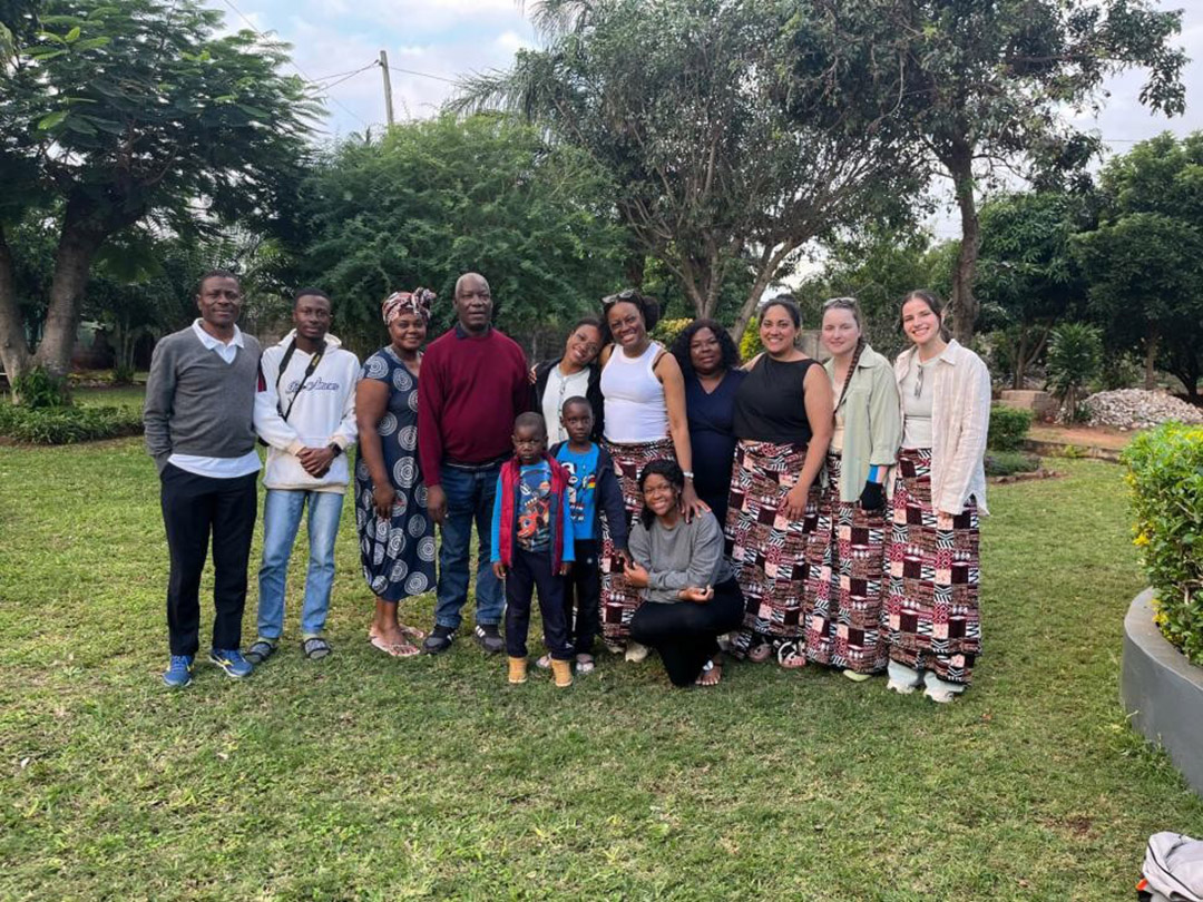 MD students Avni, Alex, and Aby with Dr. Fernanda Andre's family in Matola, wearing their gifted Capulana. (Photo: Submitted)